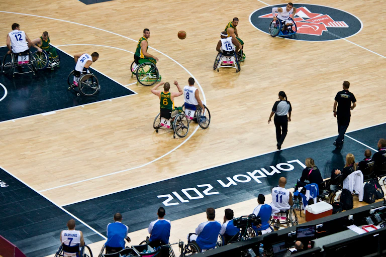 Wheelchair basketballers on a court with a ball.