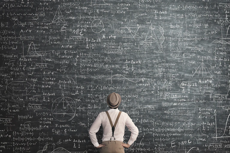 Man viewing a blackboard filled with equations.