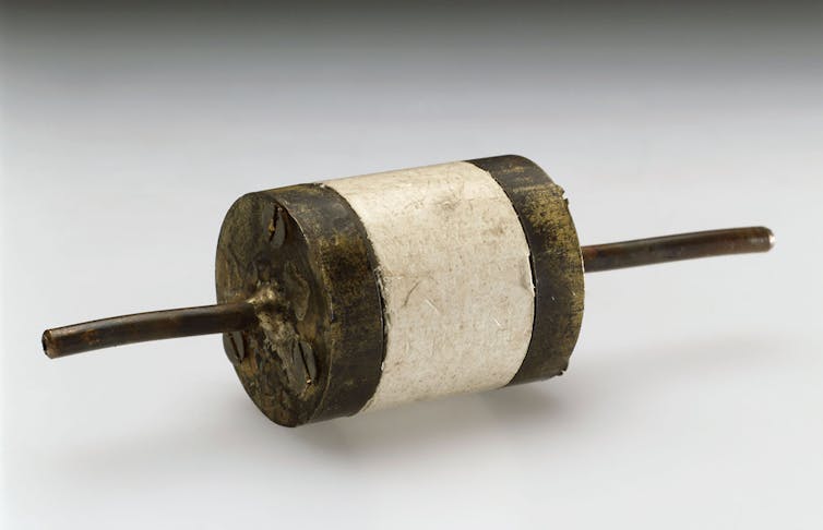 A small device resembling a spindle with a white band in the middle.