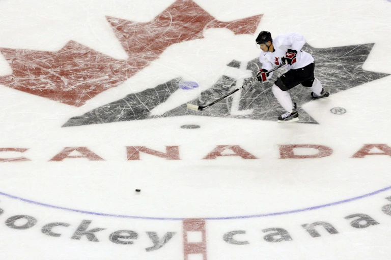 A hockey player skates across a Hockey Canada logo