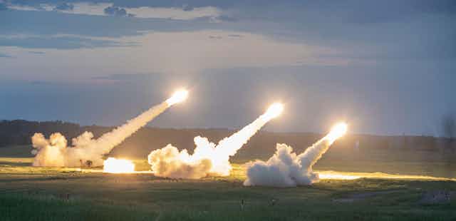 Missiles launch into sky from grassed area