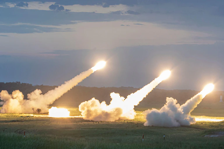 Missiles launch into sky from grassed area
