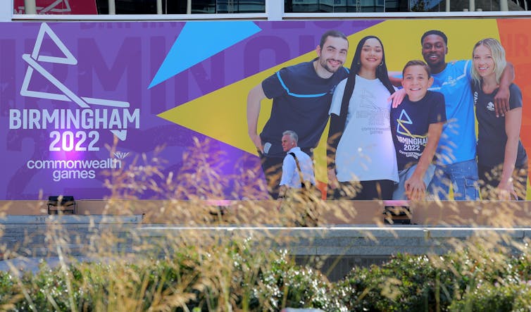 A poster advertising the Birmingham 2022 commonwealth games, with a photo of a group of young people