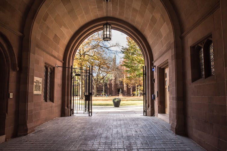 A tunnel and archway is seen on a university campus.