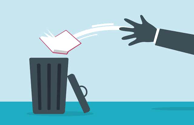 Picture of a hand throwing a book in a trash can