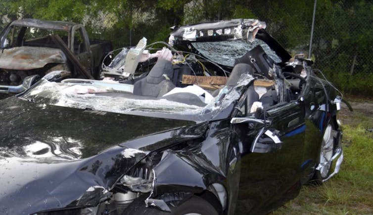 A crumpled Tesla after a car crash