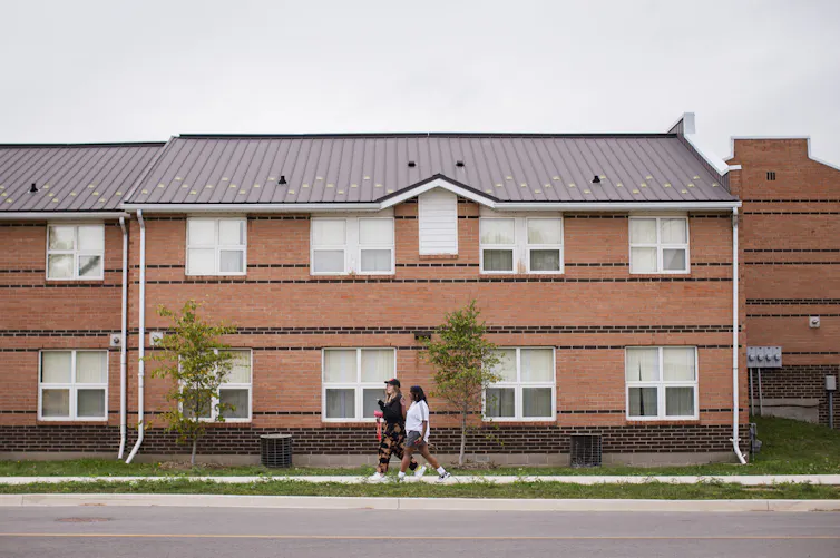 Students seen walking in front of a university building.