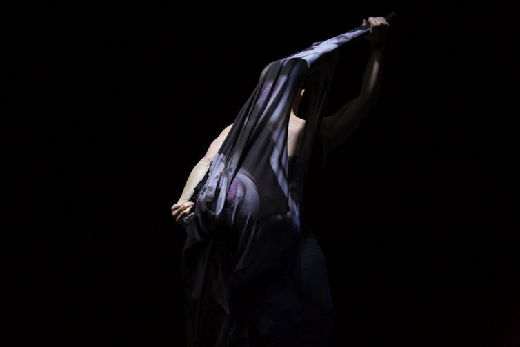 A woman obscured by a shroud