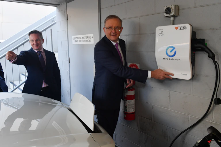 Chris Bowen and Anthony Albanese beside an electric vehicle