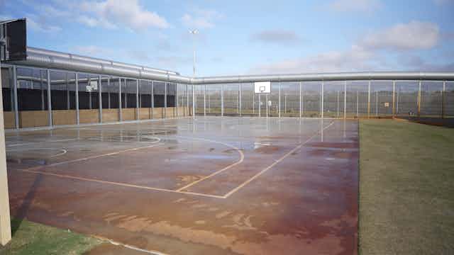 Prison fenced basketball court in Perth