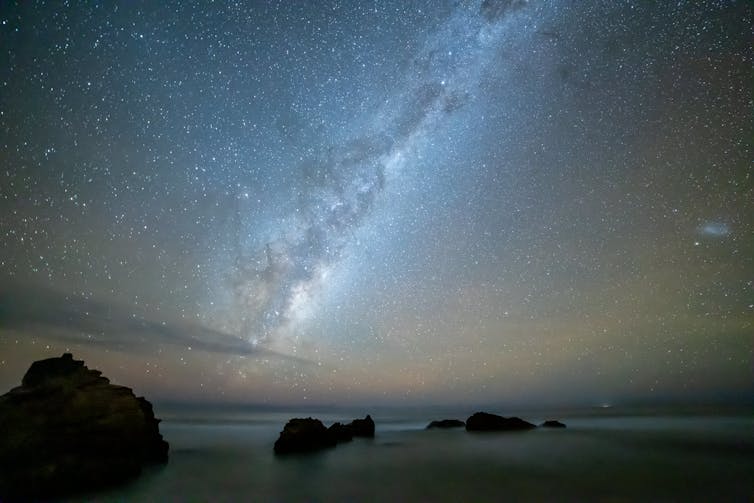 A view of the Milky Way from Earth, with rocks in the foreground