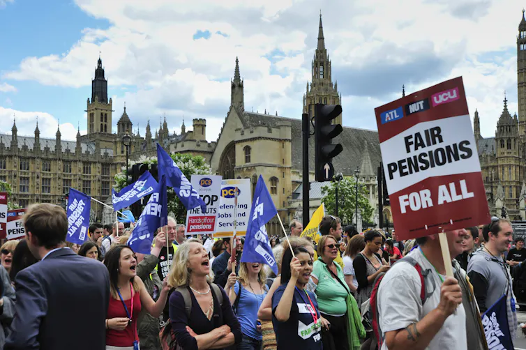 Group of protestors with signs about pensions outside UK houses of parliament