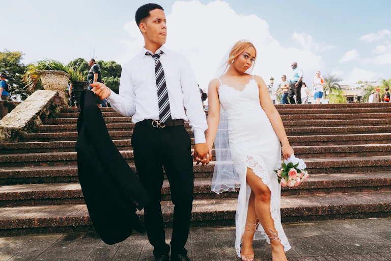 A wedding couple on some steps in the sunshine