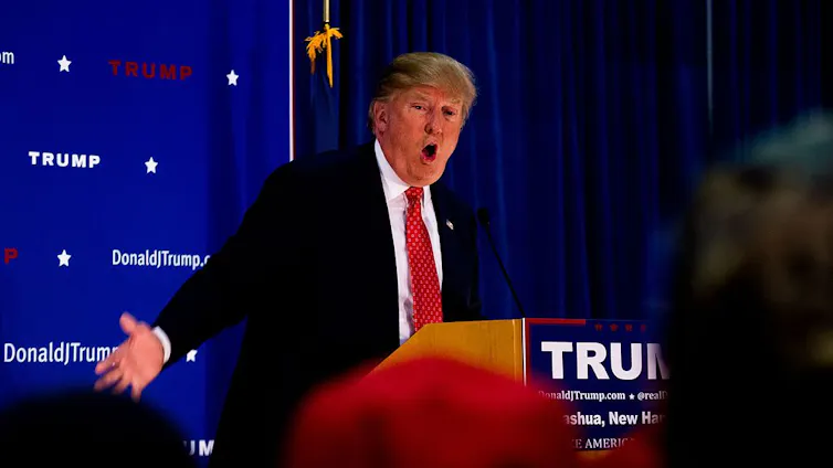 Donald Trump hace aspavientos detrás de un atril.