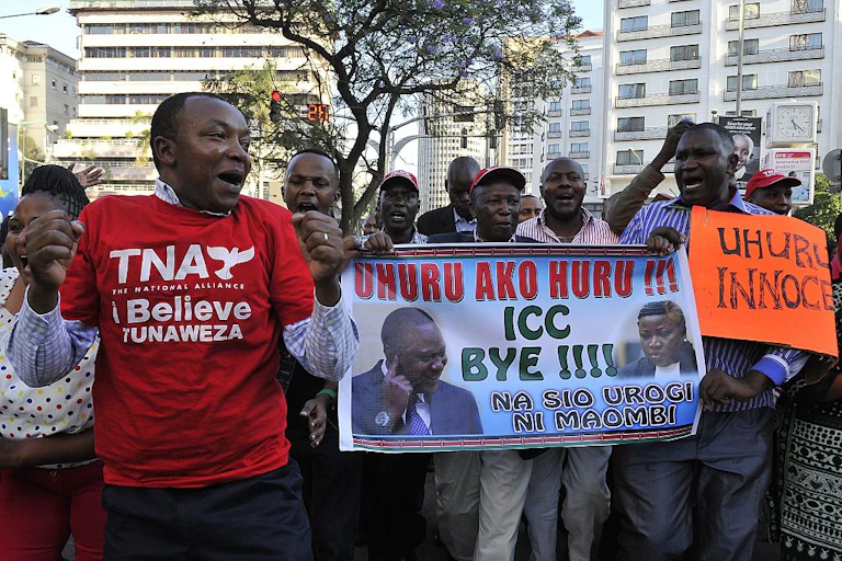 A group of people holding up posters saying ICC Bye.