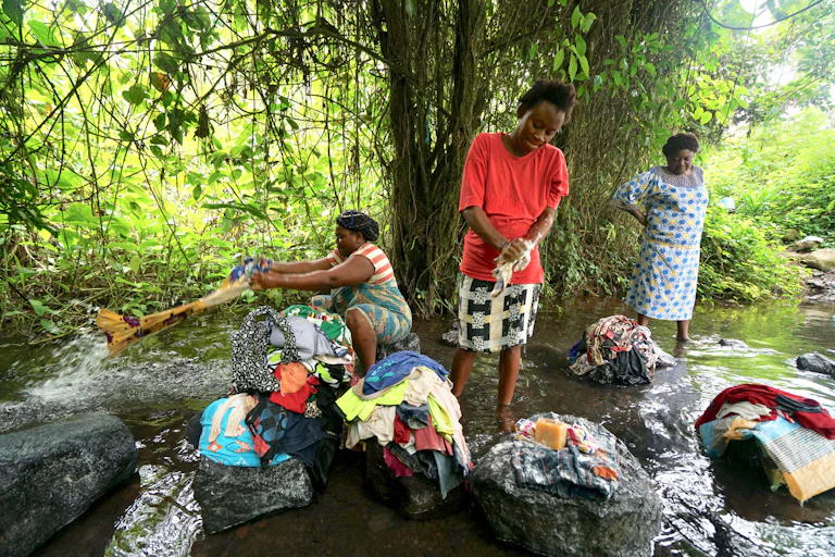 Women washing clothes in a stream.