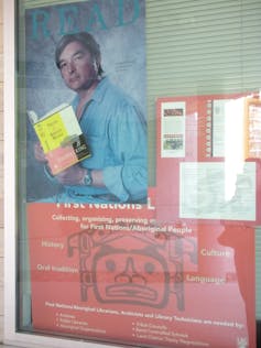A poster is seen on a door of a man that says READ.