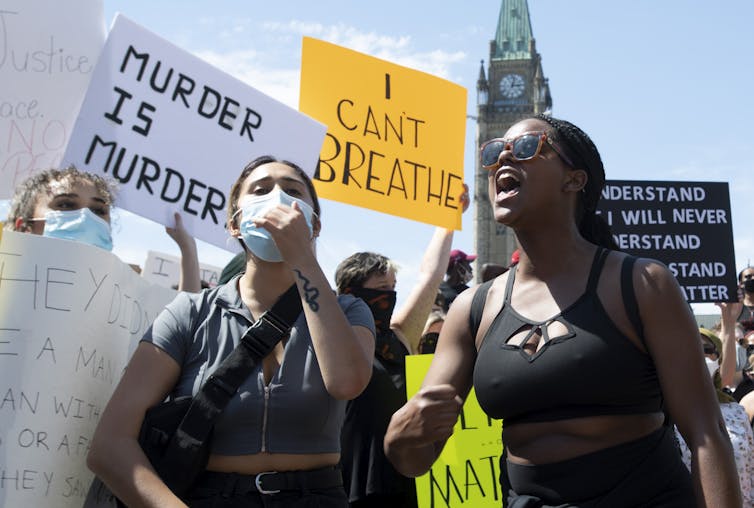 People seen at a protest in front of the Canadian Parliament buildings.