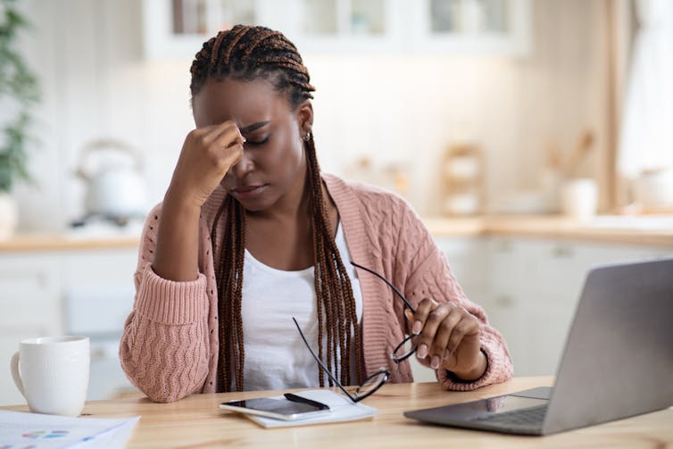 A woman looks tired at work.