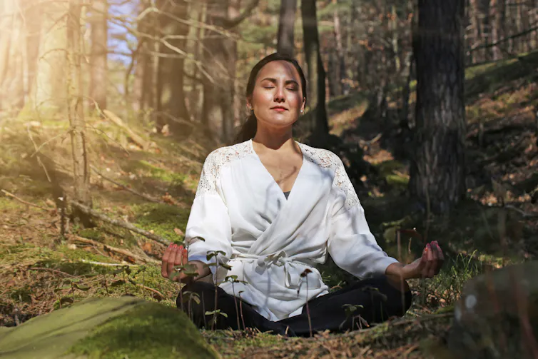 Lady meditates in forest