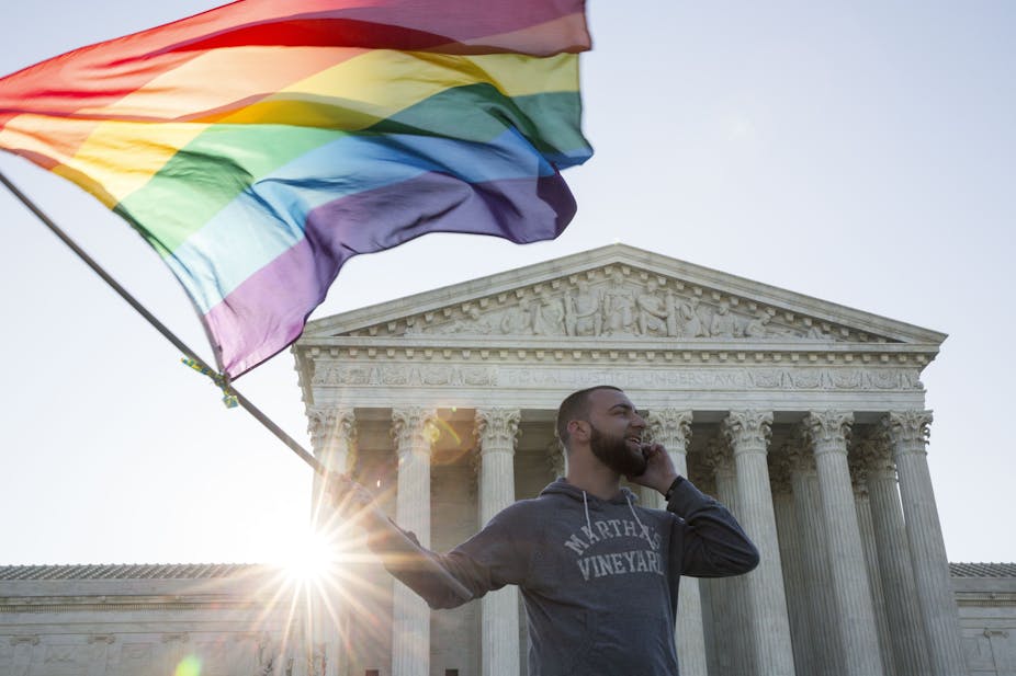 A man waves a rainbow flag outside the Supreme Court 