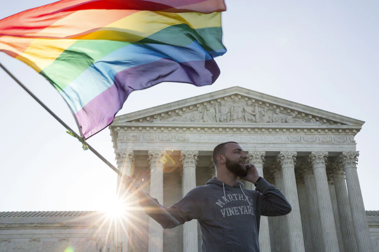 A man waves a rainbow flag outside the Supreme Court