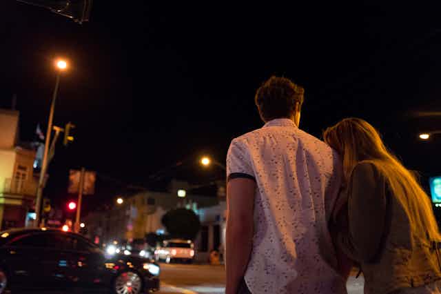 Young couple walks at night.