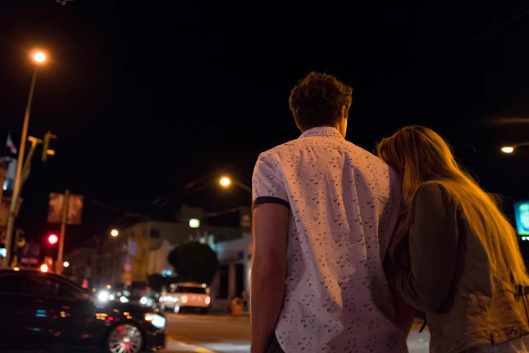 Young couple walks at night.