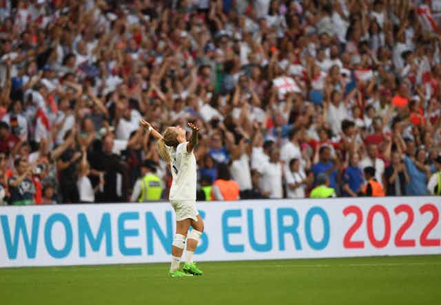 Woman footballer in front of crowd