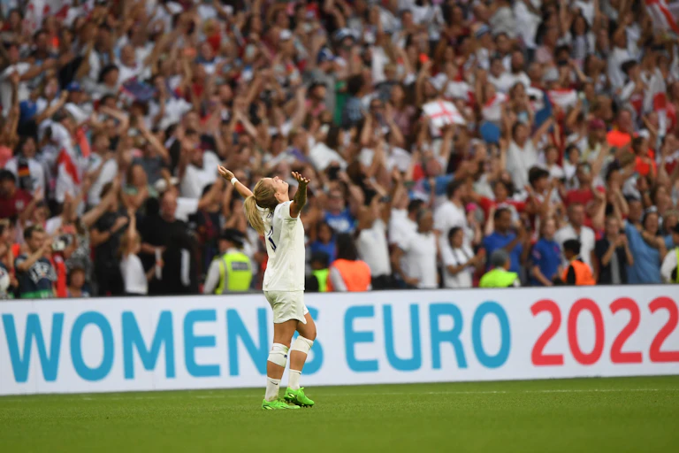Woman footballer in front of crowd