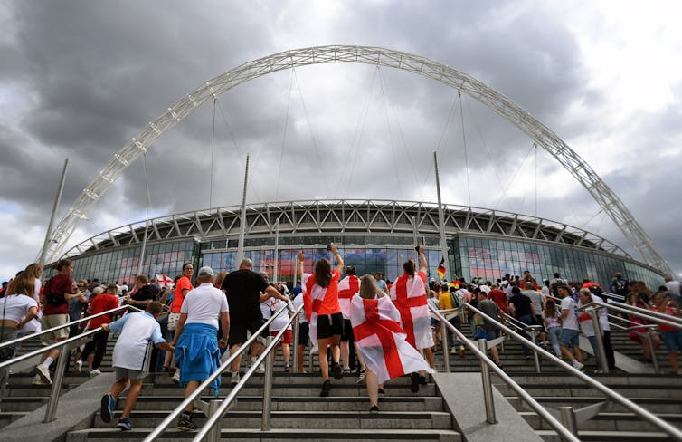Fans walk up the steps to the stadium