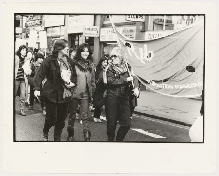 Picture of women holding a banner at a protest.
