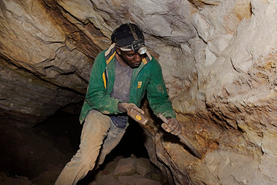 An illegal gold miner collects ore from a seam in an abandoned mine in Roodepoort, South Africa.