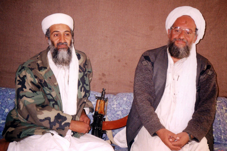 Osama bin Laden sits with his then adviser Ayman al-Zawhir, both wearing traditional Islamic dress.