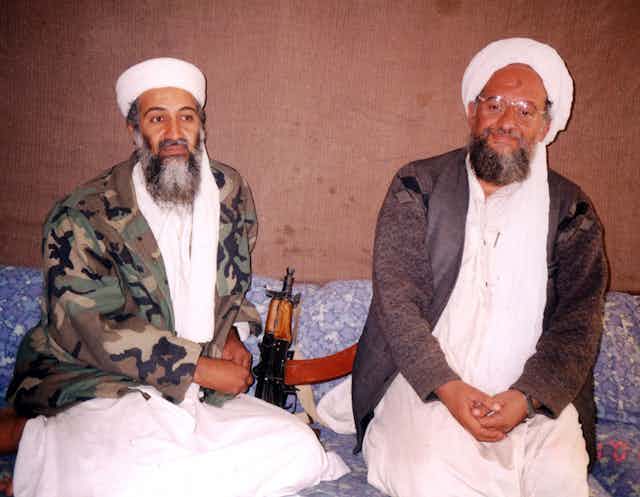 Osama bin Laden se sienta con su entonces asesor Ayman al-Zawhir, ambos con el traje tradicional islámico.