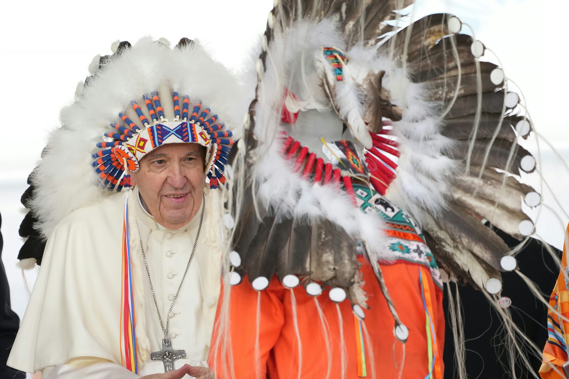 A man in white robes wears a headdress