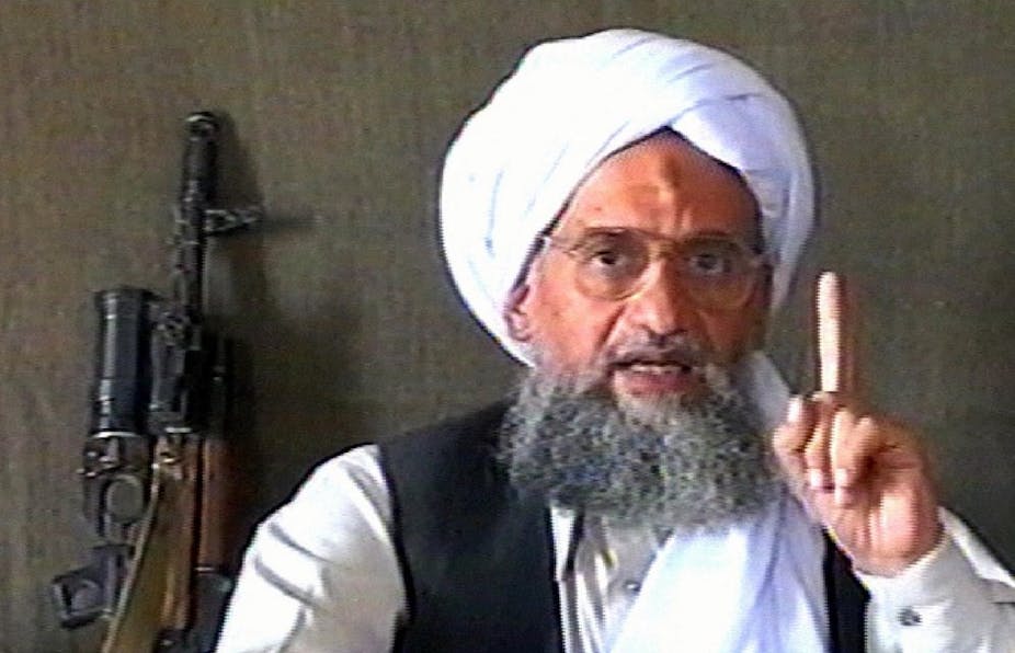 Al-Zawahiri s'exprime lors d'une allocution. Un fusil d'assaut est en arrière plan. 