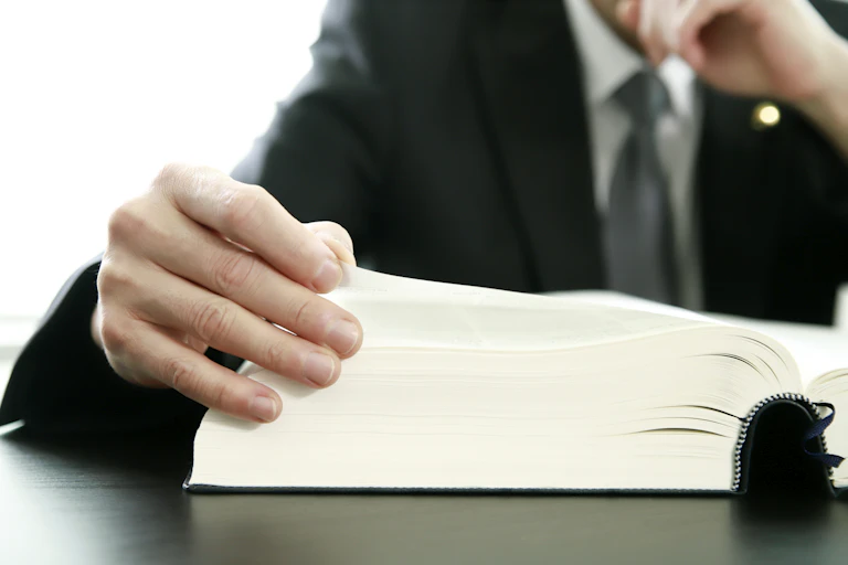 A person pages through a thick book