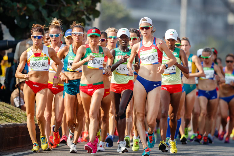 Women race walkers compete in a race.