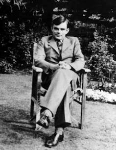 Fotografía de Alan Turing sentado en una silla.