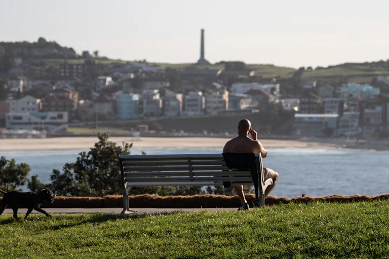 Person sitting on bench alone in Sydney
