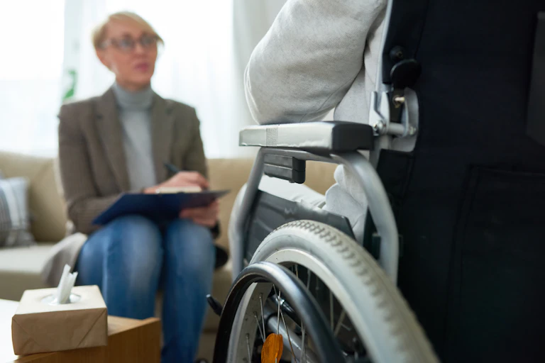 woman sitting faces person in wheelchair