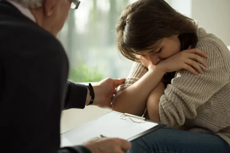 man comforts woman by patting her arm
