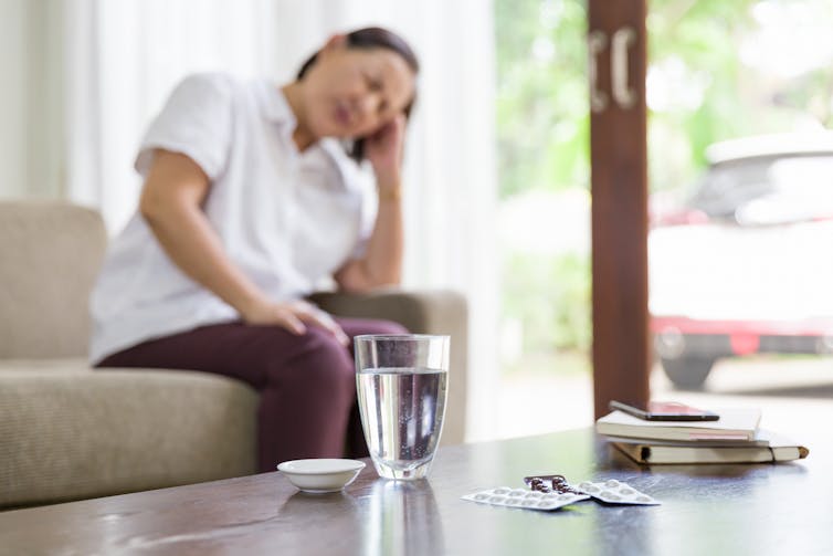 Older woman sits on a couch