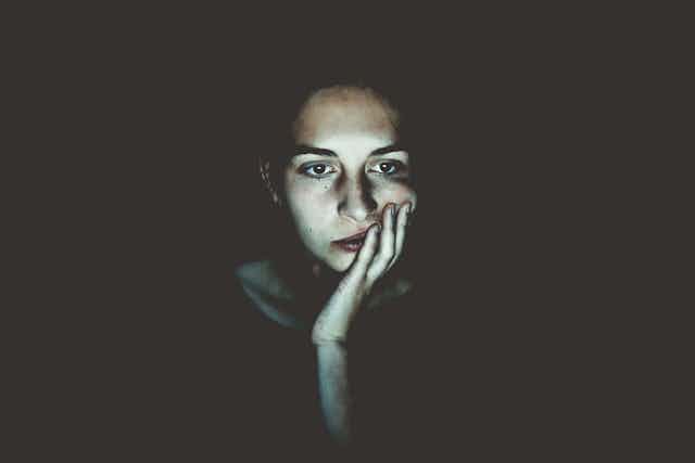 Woman staring at computer screen in dark