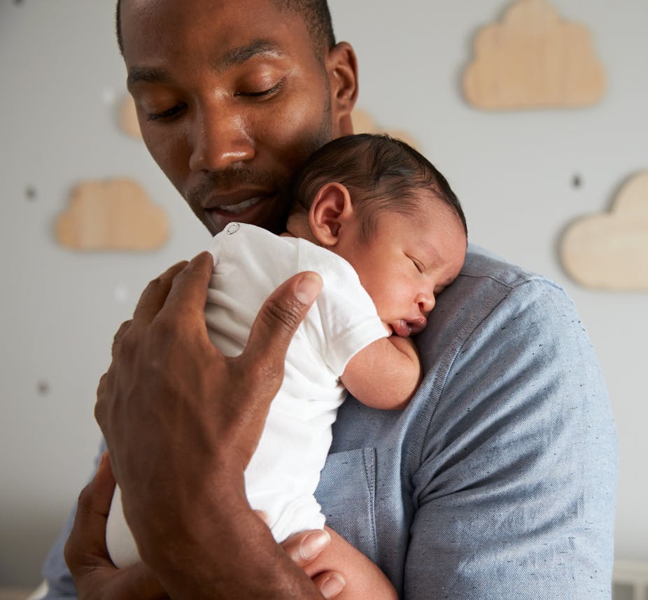 Father holding sleeping baby
