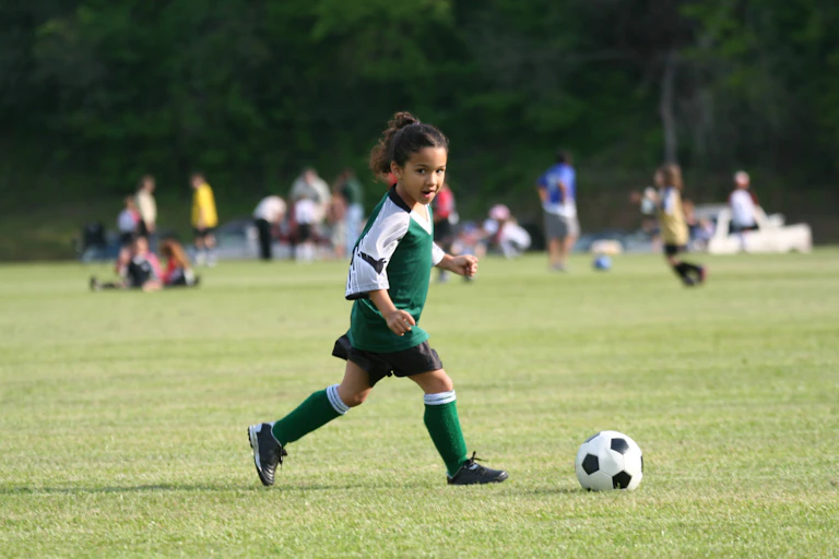 Girl kicking a football.