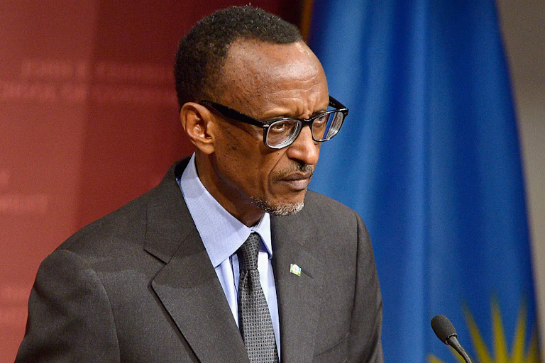 Man on a podium with the Rwandan flag behind him.