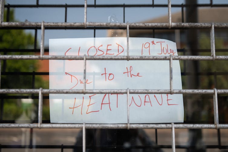 Handwritten sign saying business is closed due to heatwave.