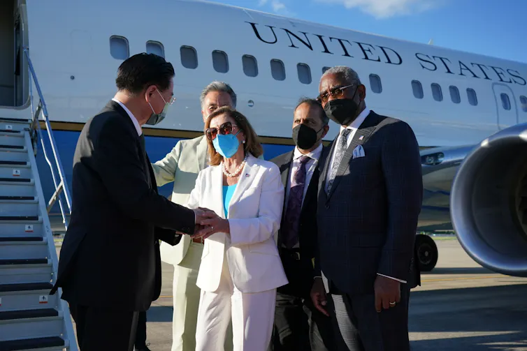 Taiwan Foreign Minister Joseph Wu (R) shaking hands with US House Speaker Nancy Pelosi (C), before she boards Air Force One to return to the US.